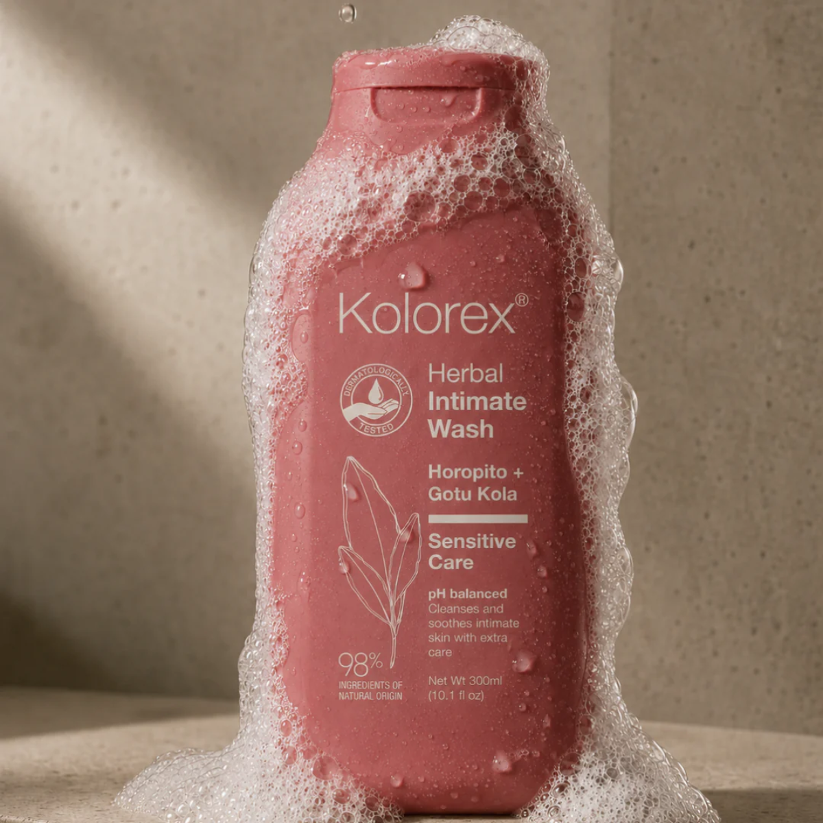 Pink bottle of Kolorex Intimate Wash bottle with foam on it from the shower