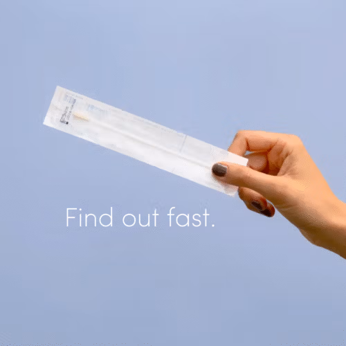 A hand holds a Juno vaginal microbiome swab ready to find out what's living in her vagina